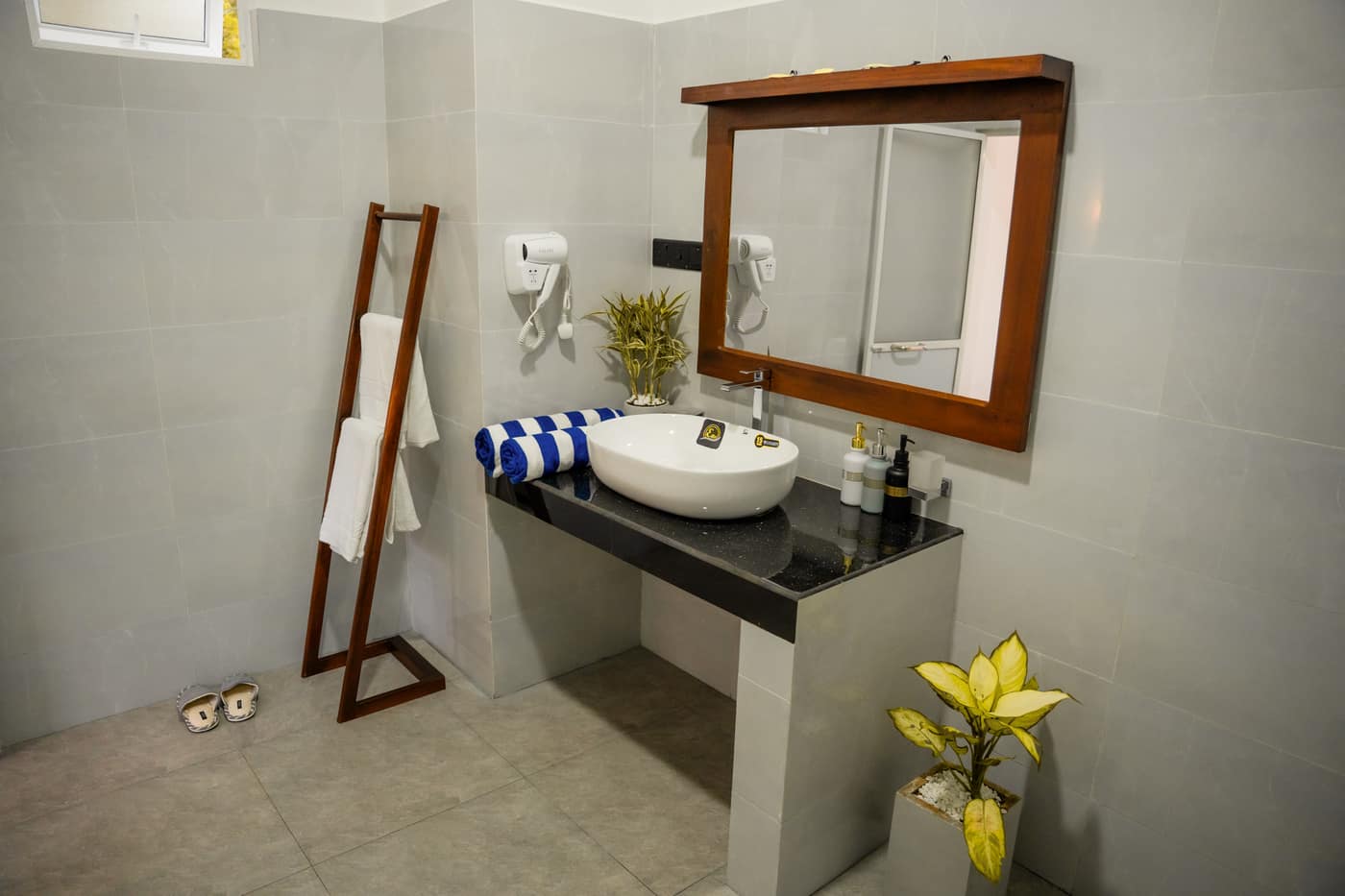 One of the two private bathrooms — a round basin on a stone counter, mirror, and folded towels
