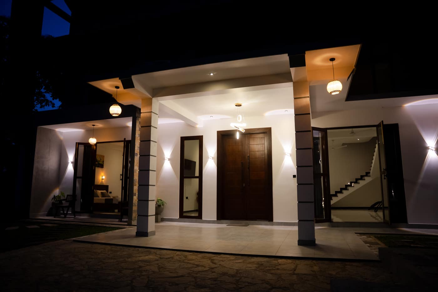 The front of the villa at night, the entrance and the walkway lit