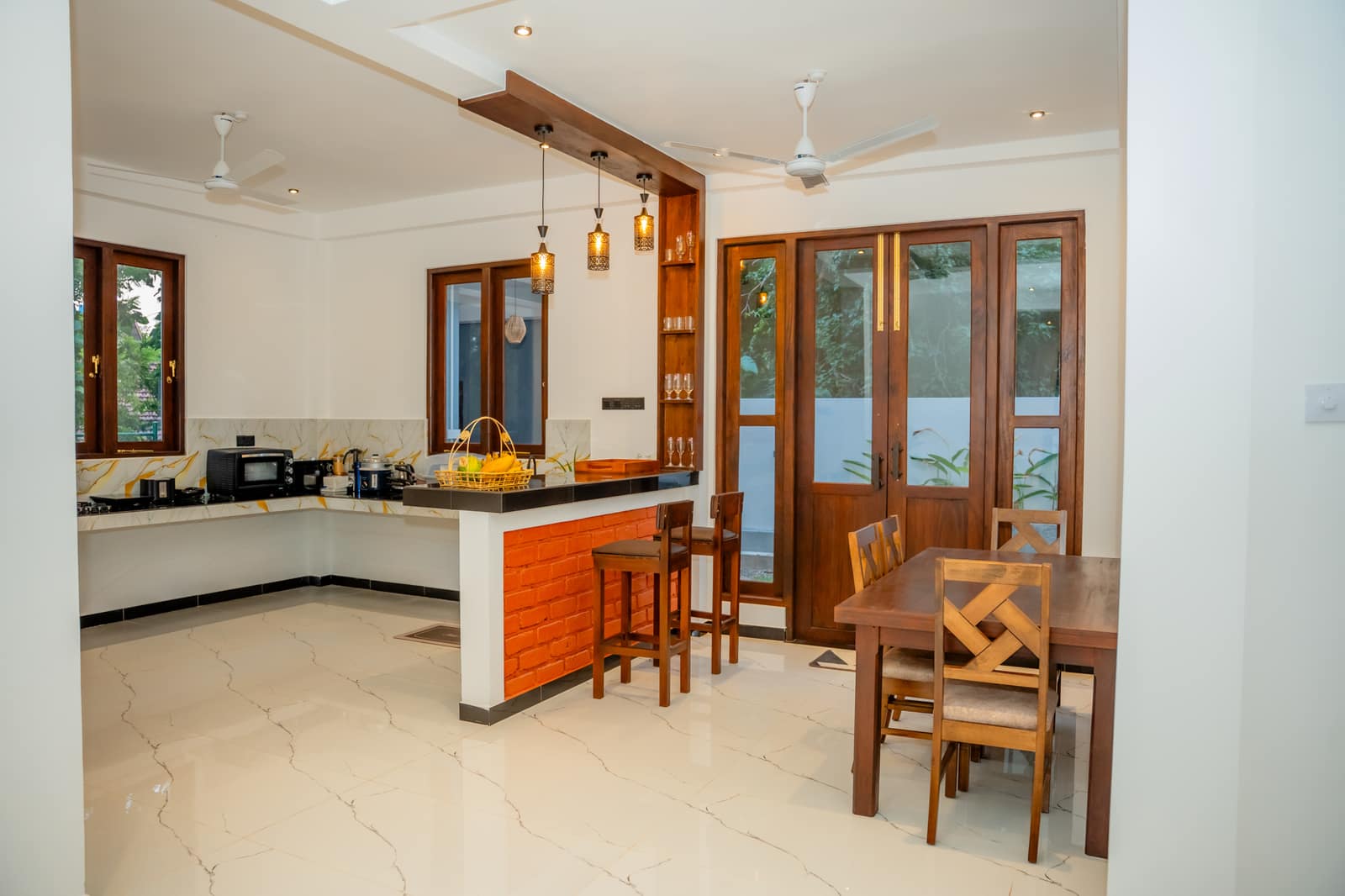 The guest kitchen and dining area, with a breakfast counter, stools and a table by the doors