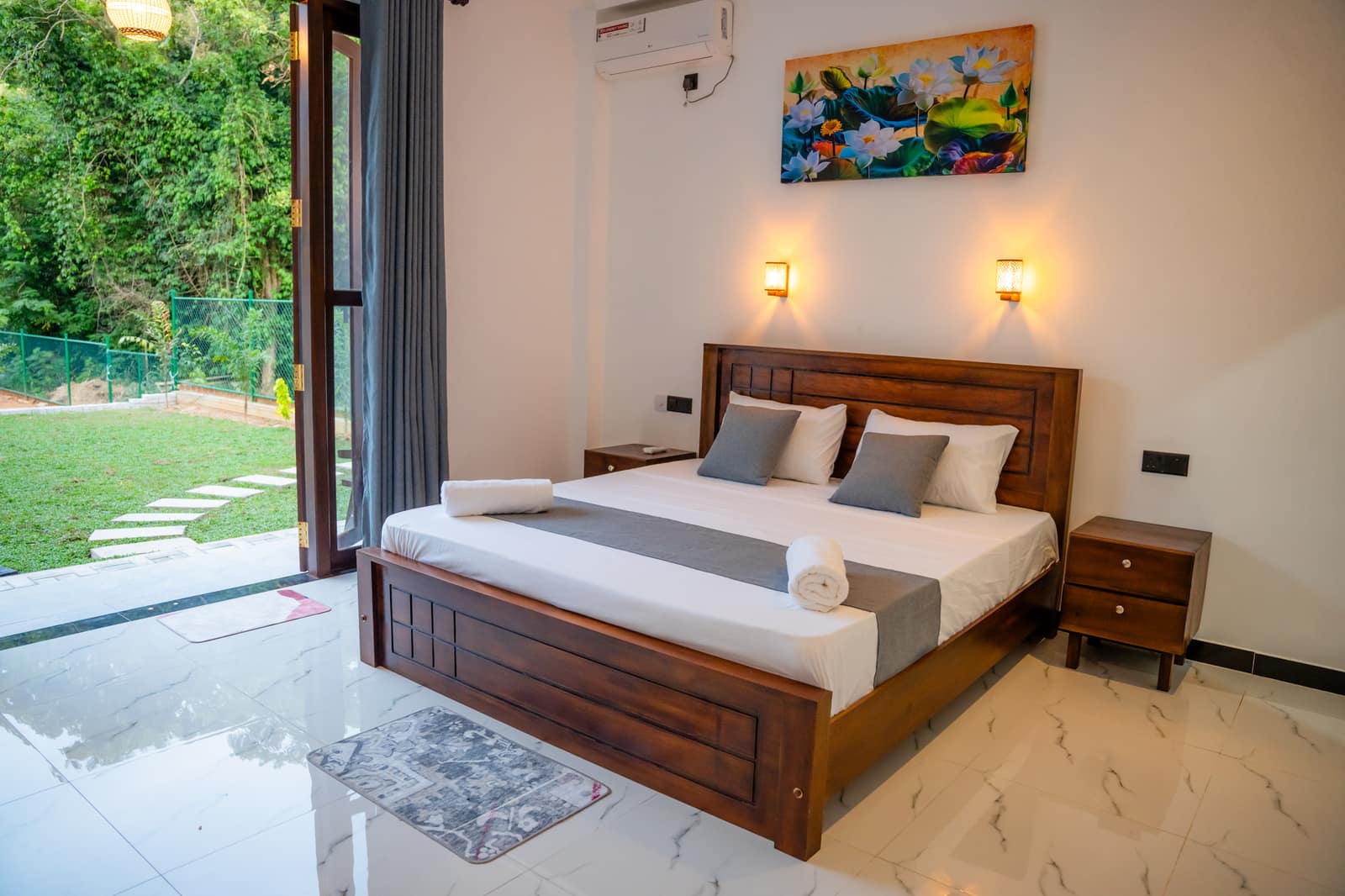 The Deluxe King Room with its doors folded open onto the terrace and the garden beyond